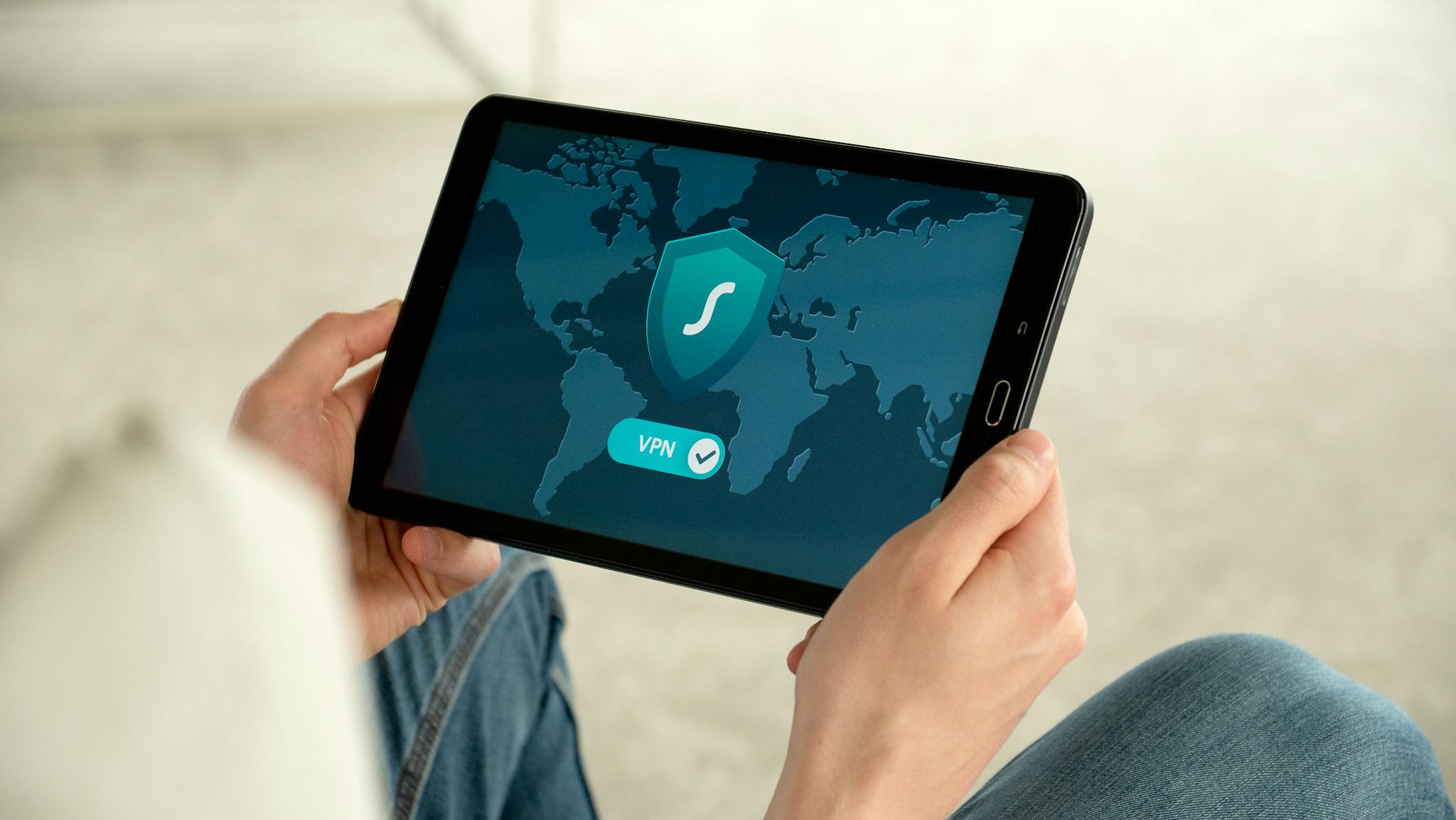 Person holding tablet with VPN connection screen for secure internet browsing.